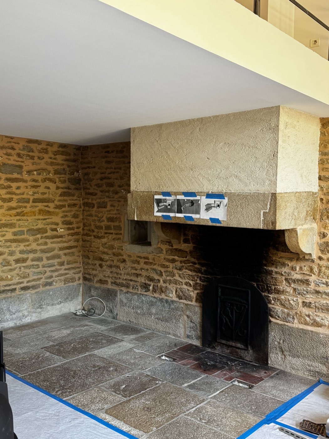 Old fireplace with stone corbels and cast-iron fireback before the work, 3D views of the future masonry heater resting on the lintel