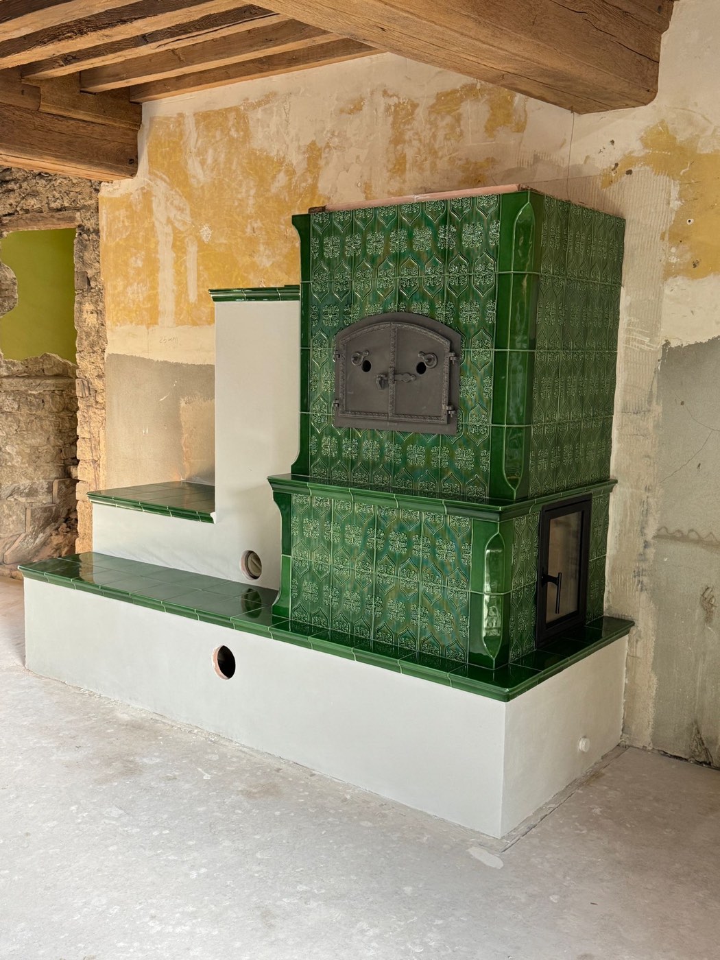 Green tiles, oven and two heated benches under the beams