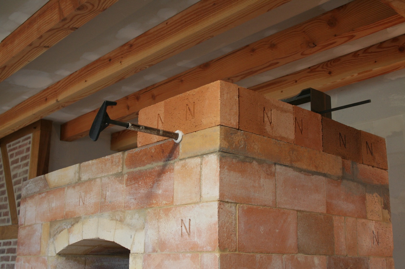 Crown of the heater in marked bricks, held by clamps while the mortar sets