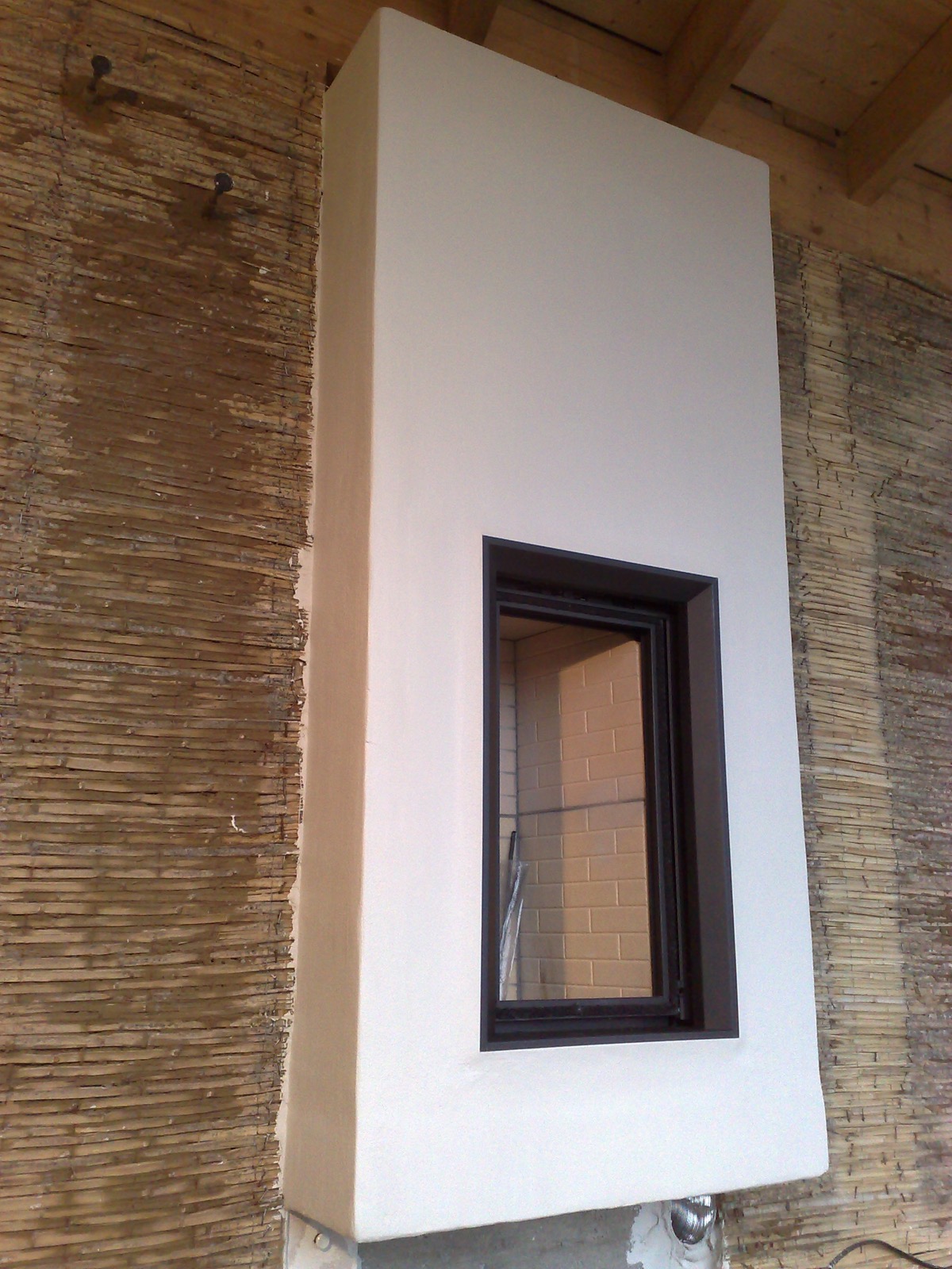 A heat-storage fireplace on a reed-prepared wall