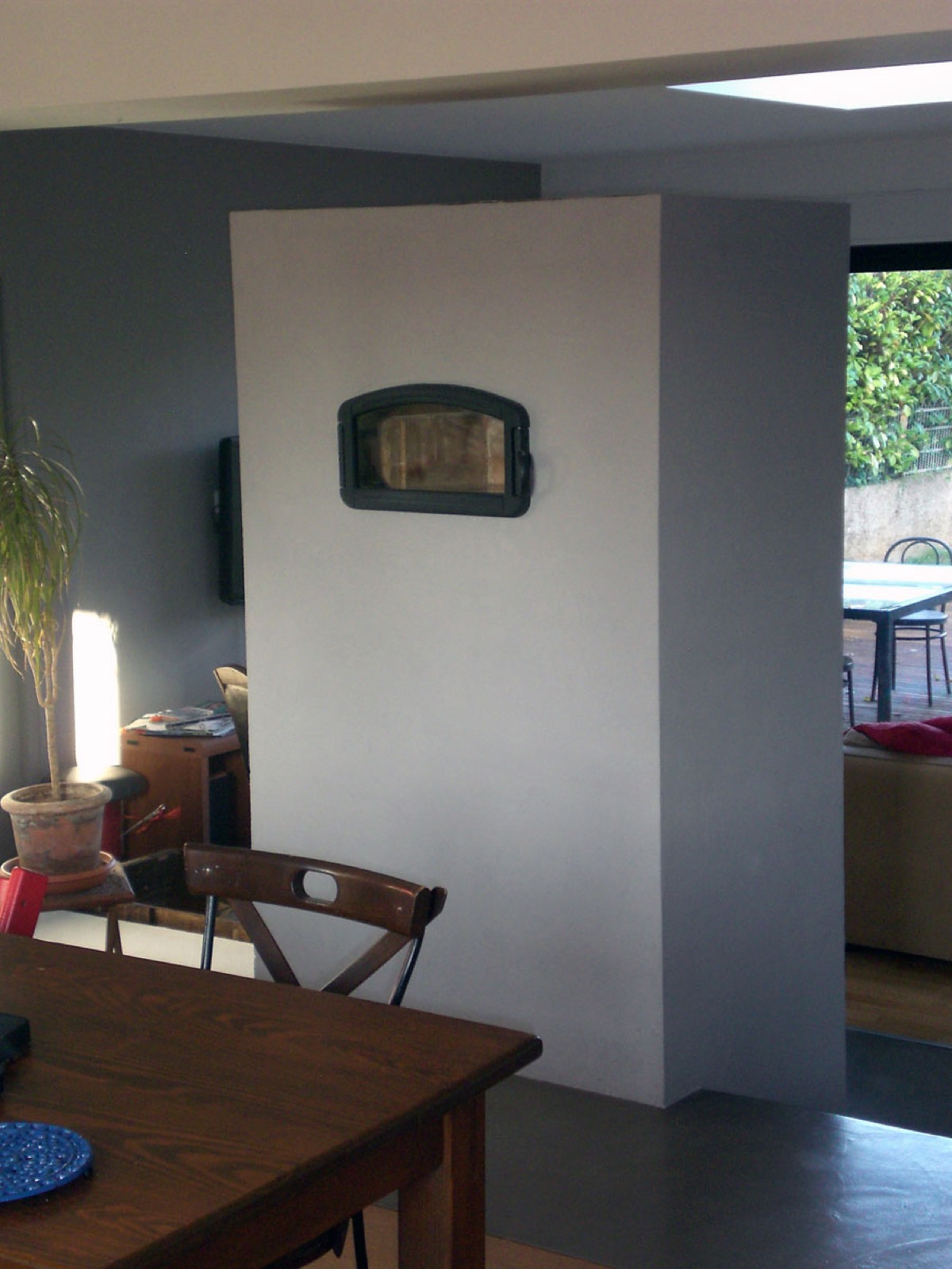 Another view of the pale rendered masonry heater in the living room