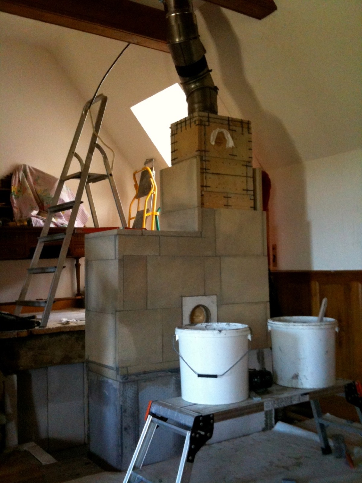 Parte alta de una estufa de masa de elementos prefabricados, con su coronamiento y la conexión del conducto de acero inoxidable al remate de chimenea