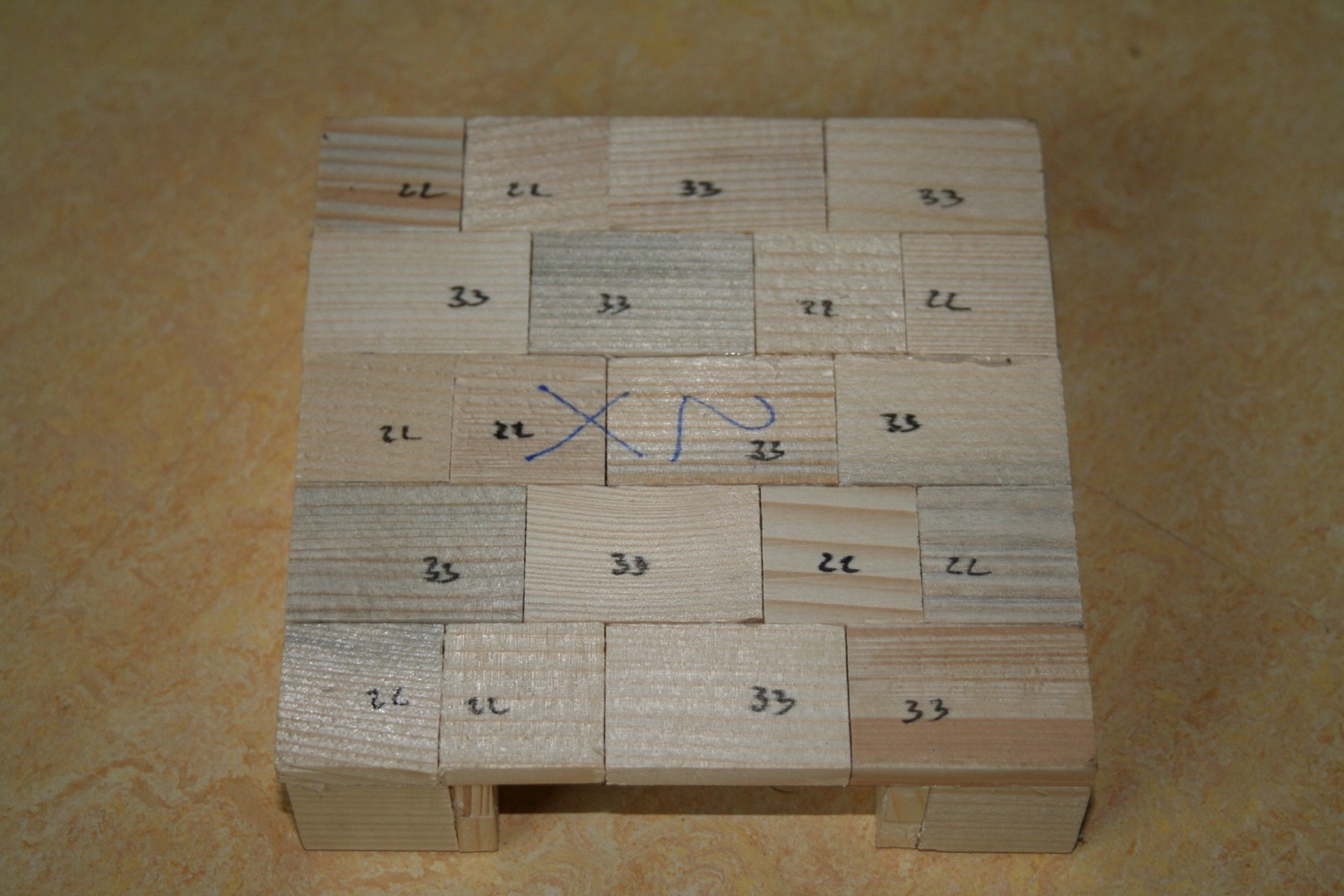 Model seen from above: wooden blocks numbered in pencil 22, 33, 35, forming the base of a masonry heater
