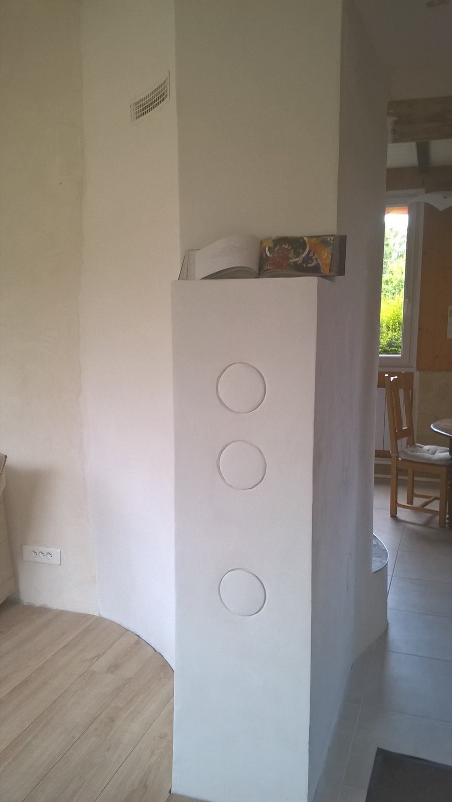 Rear face of the masonry heater, rendered white, with three round flush cleaning doors