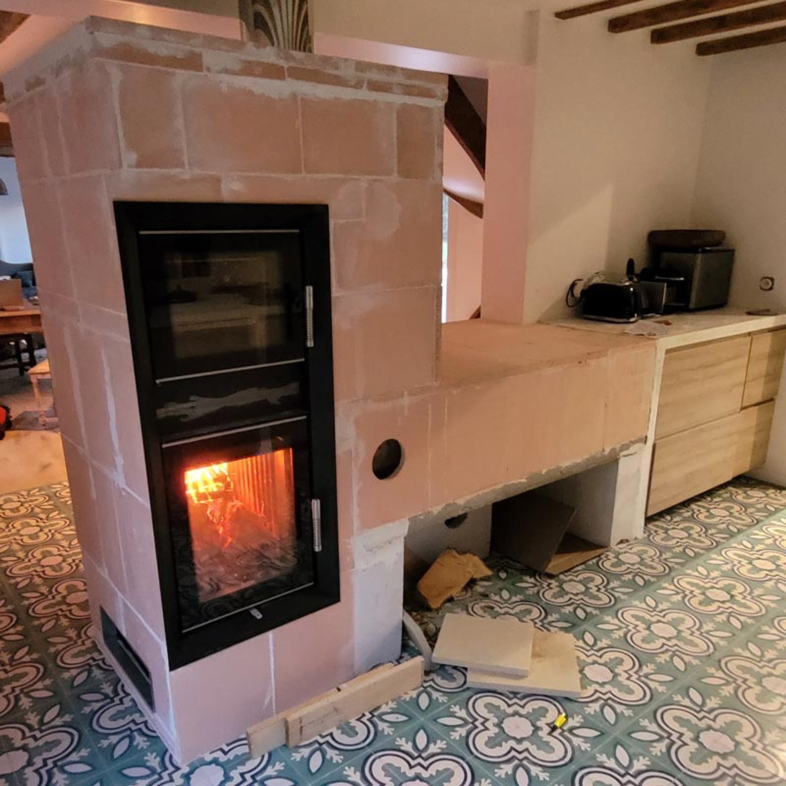 The glazed firebox and, just above it, the glazed door of the cooking oven, in the pale masonry heater core