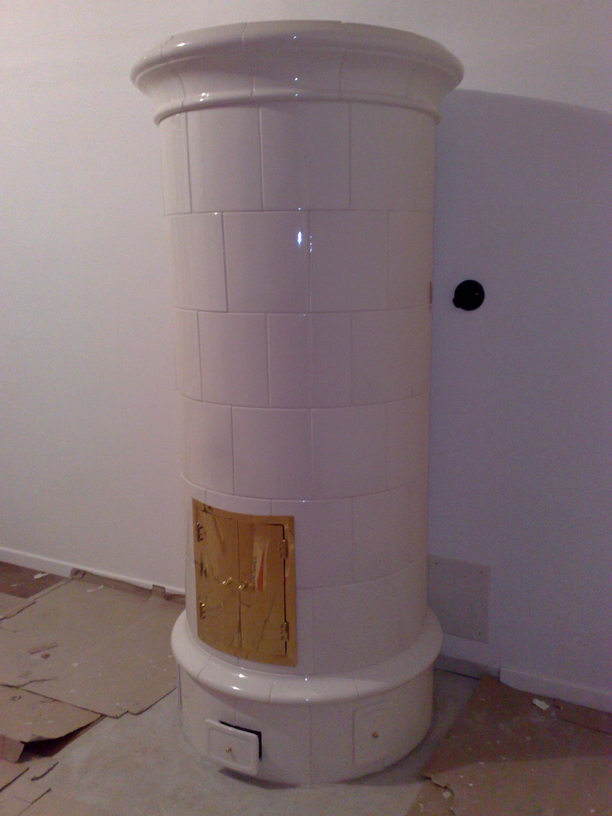 Kachelung: a round Swedish heater in white stove tiles
