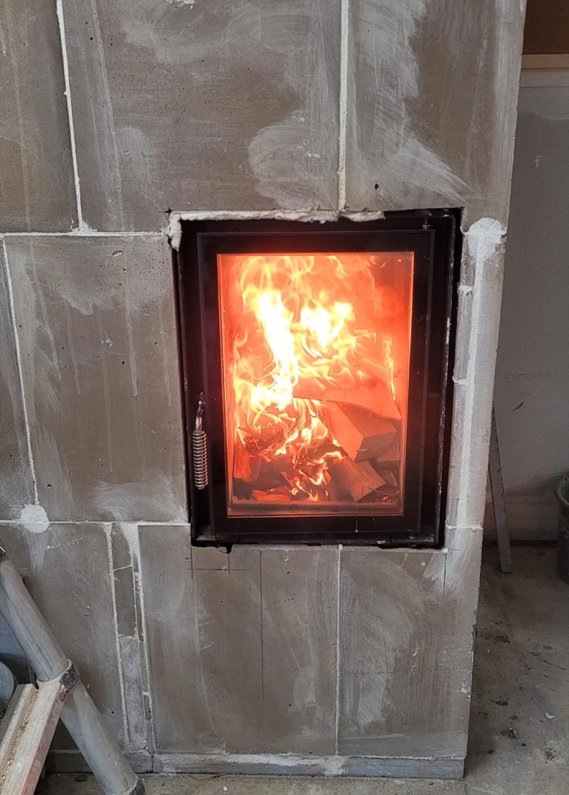 Test burn in the glazed firebox, cladding in still-bare sand-lime blocks