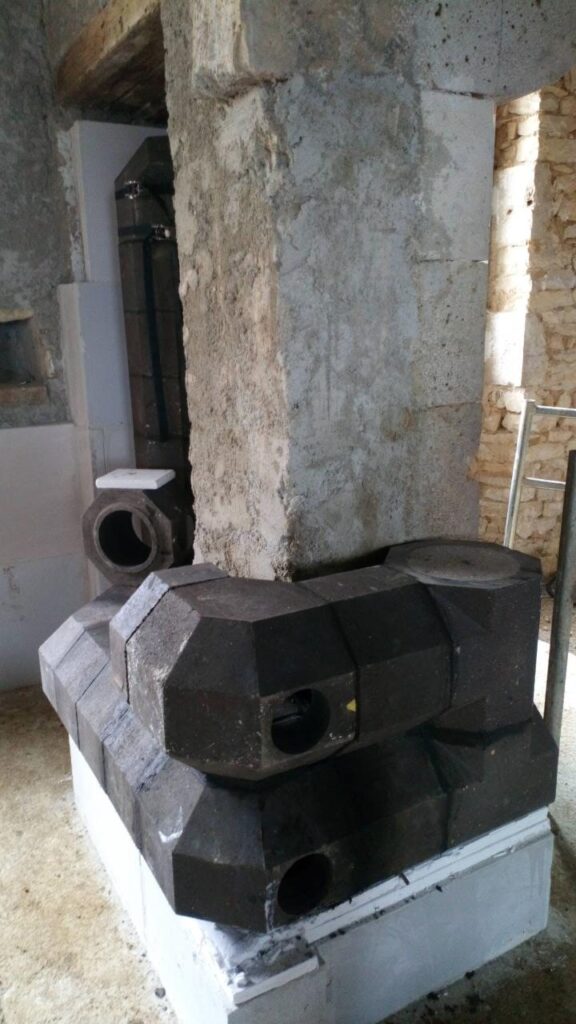 Núcleo de la estufa de masa en elementos refractarios oscuros, montado junto a un pilar de piedra