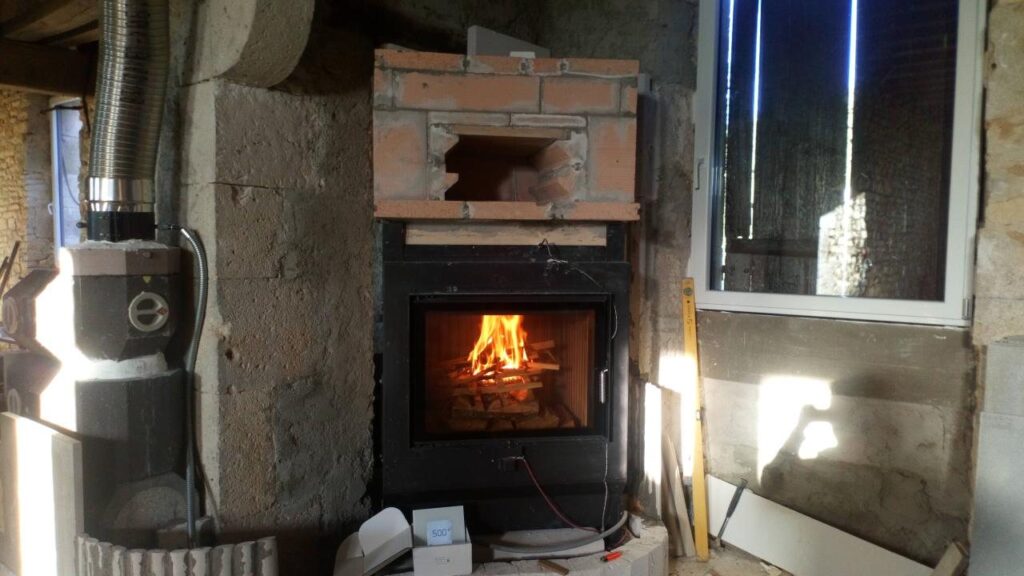 Primer fuego de prueba en el hogar de la estufa de masa, con el horno de pan de ladrillo encima